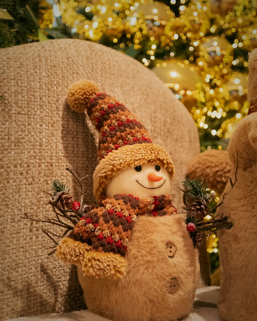 Plüsch-Schneemann vor den Lichtern des Baums