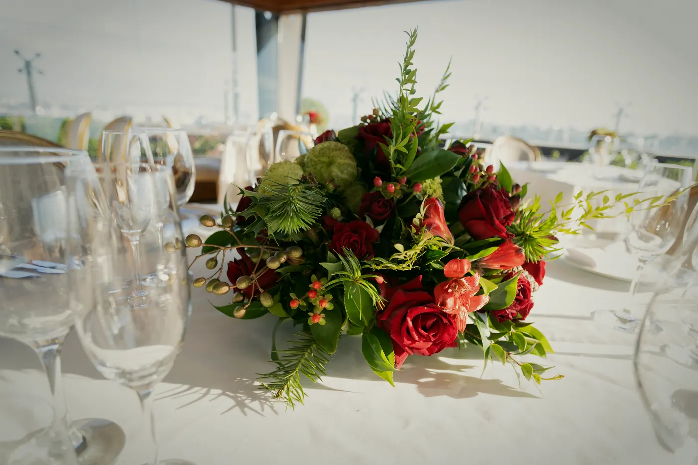Gesteck aus Rosen und Grün in der Tischmitte