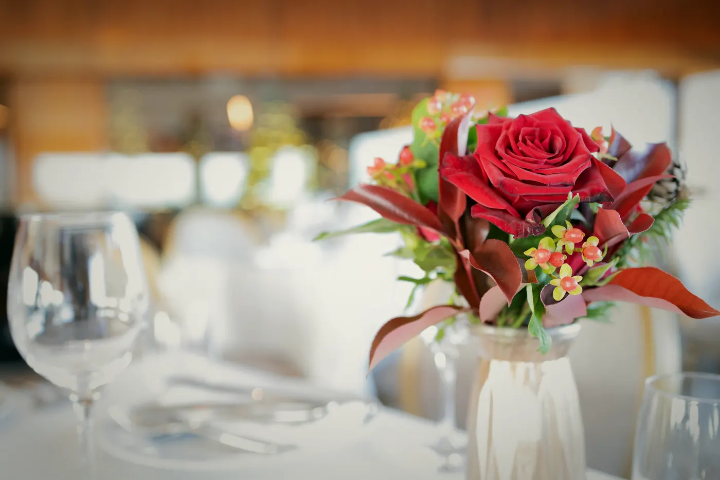 Rote Rosen und Gläser auf dem gedeckten Tisch